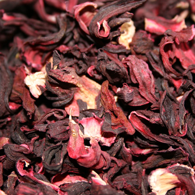 A collection of dried red hibiscus flowers stacked ,emphasizing their vivid color 